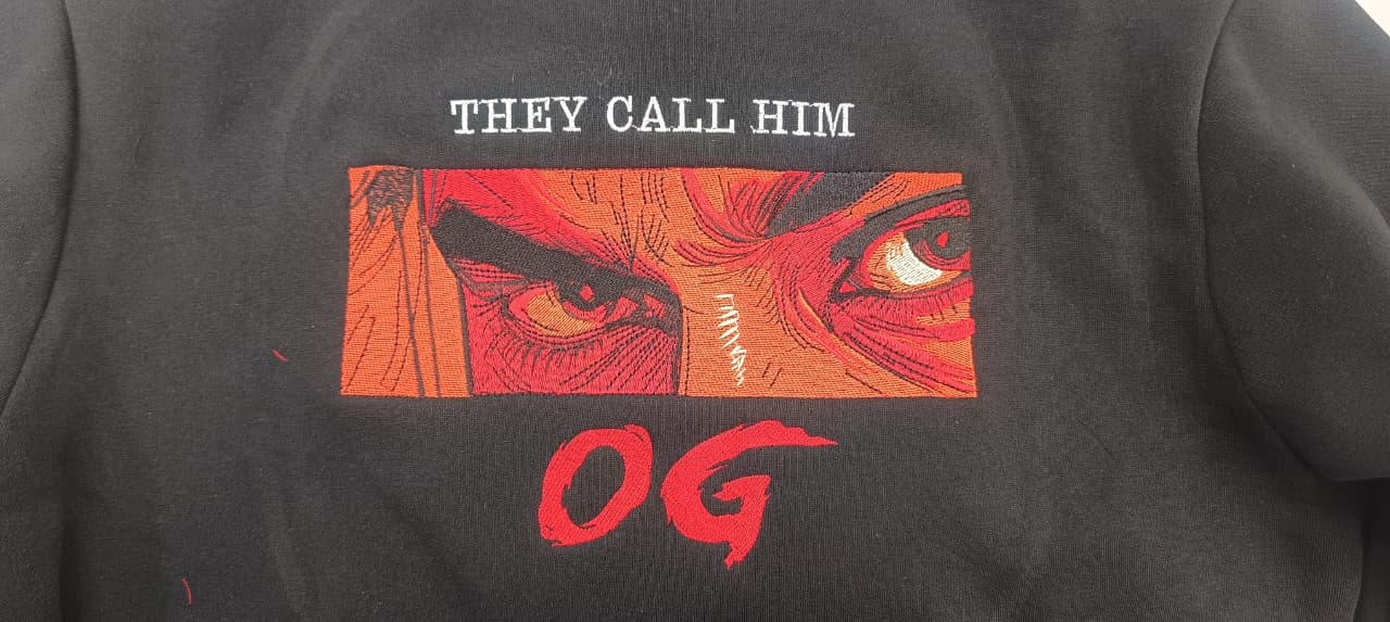 Black tee with 'They Call Him OG' embroidered artwork