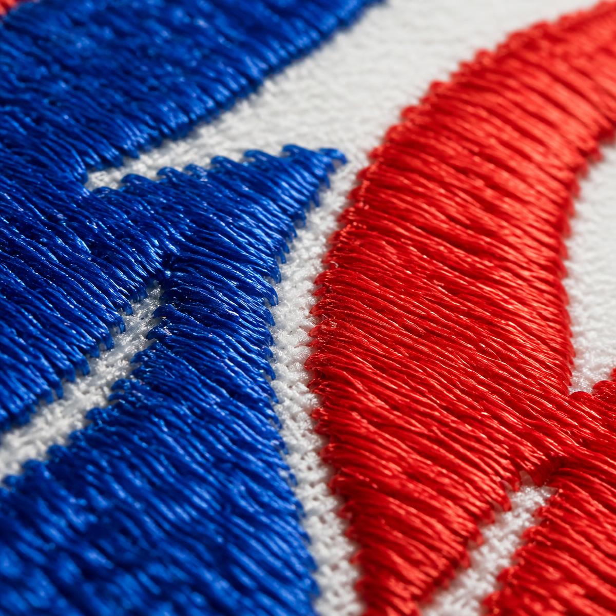Macro close-up of blue and red embroidery stitching on fabric