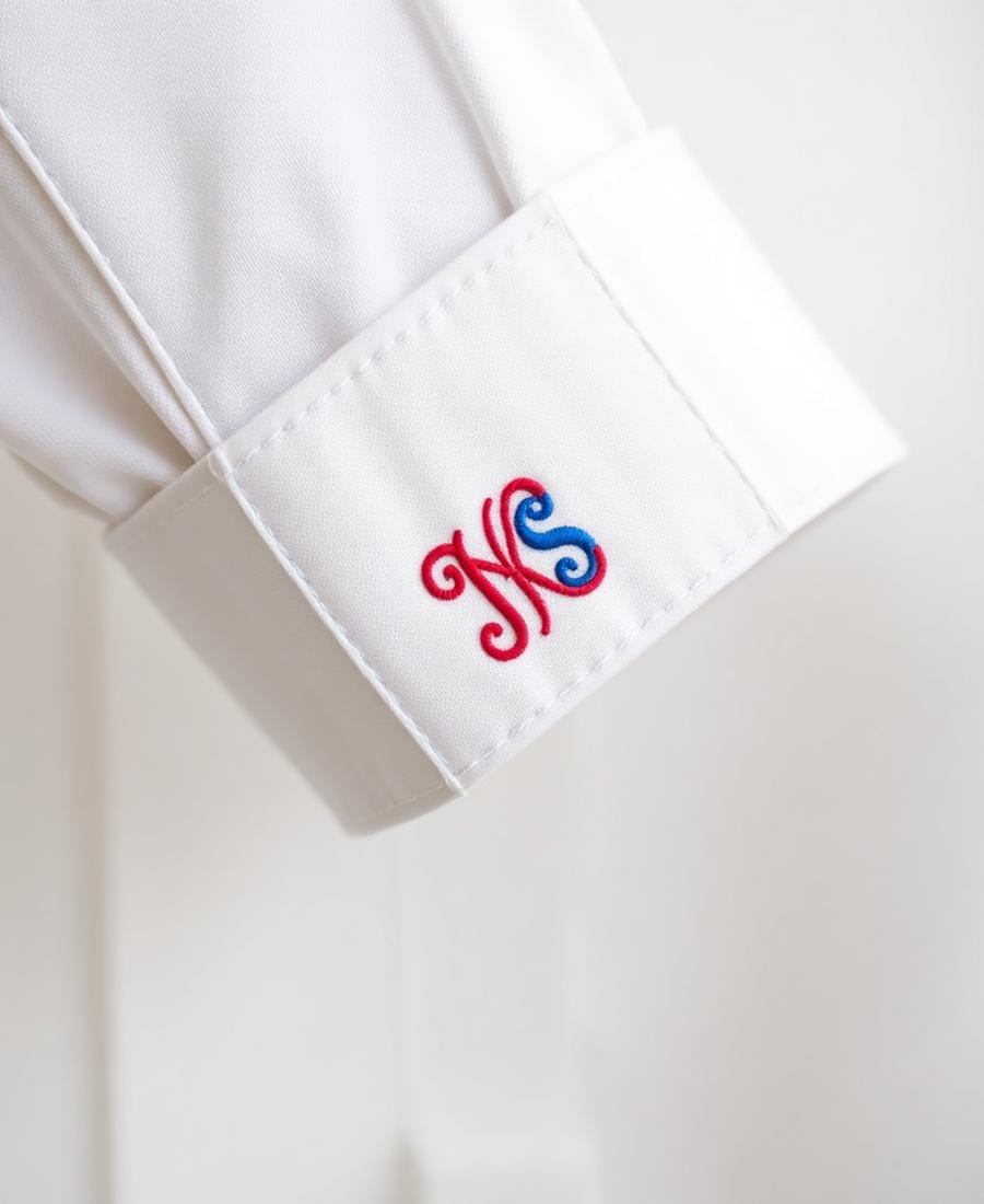 Embroidered monogram initials on a white shirt cuff